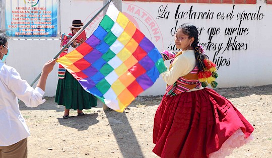 A young Aymara-woman performing a traditional dance in front of the Ajoya health center that the project supports through the construction of a intercultural delivery room.